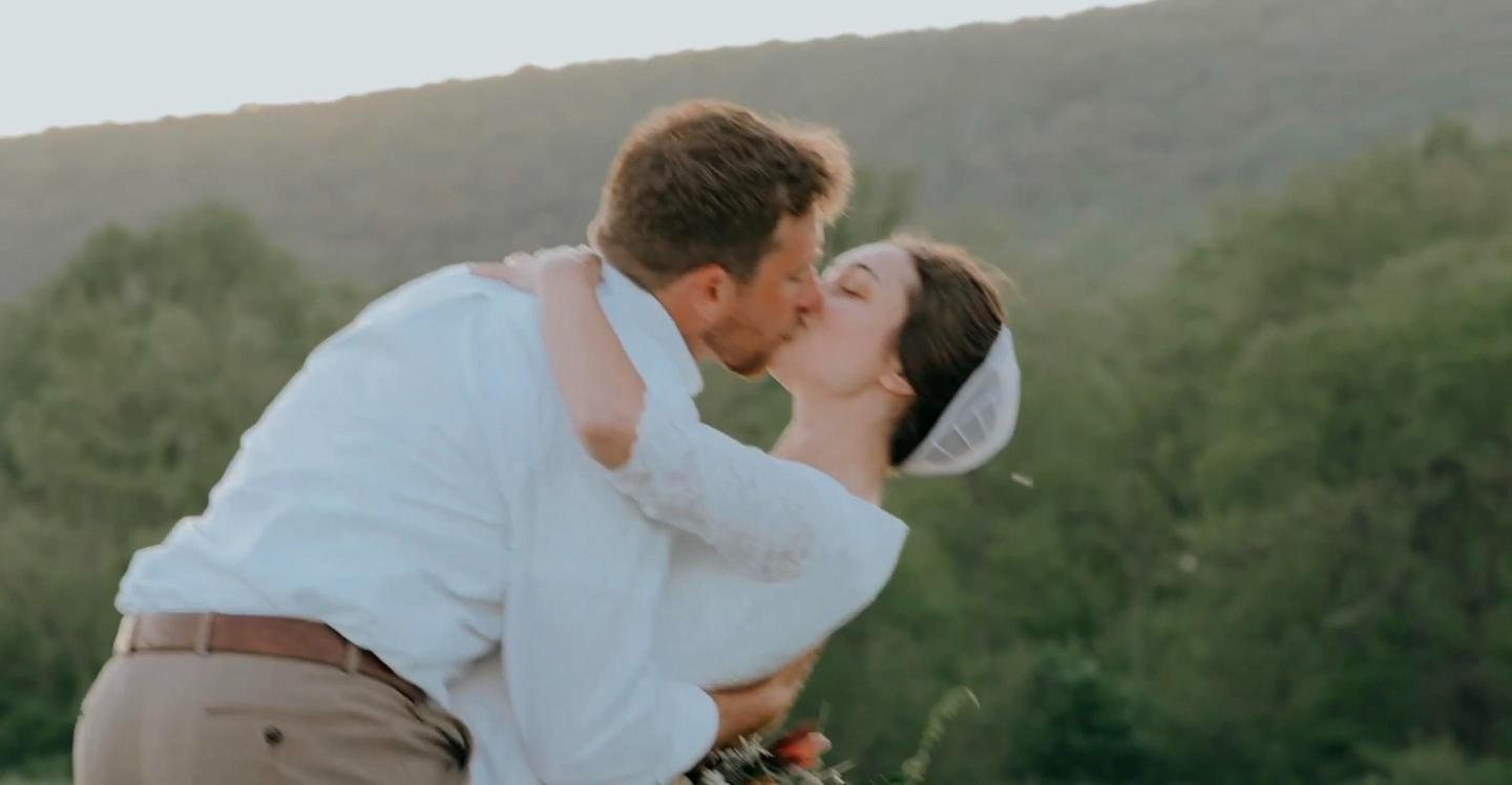 Couple kissing with the mountains behind them