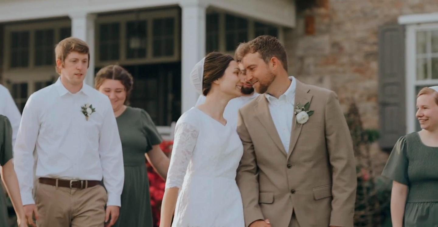 Newlyweds walking with their wedding party
