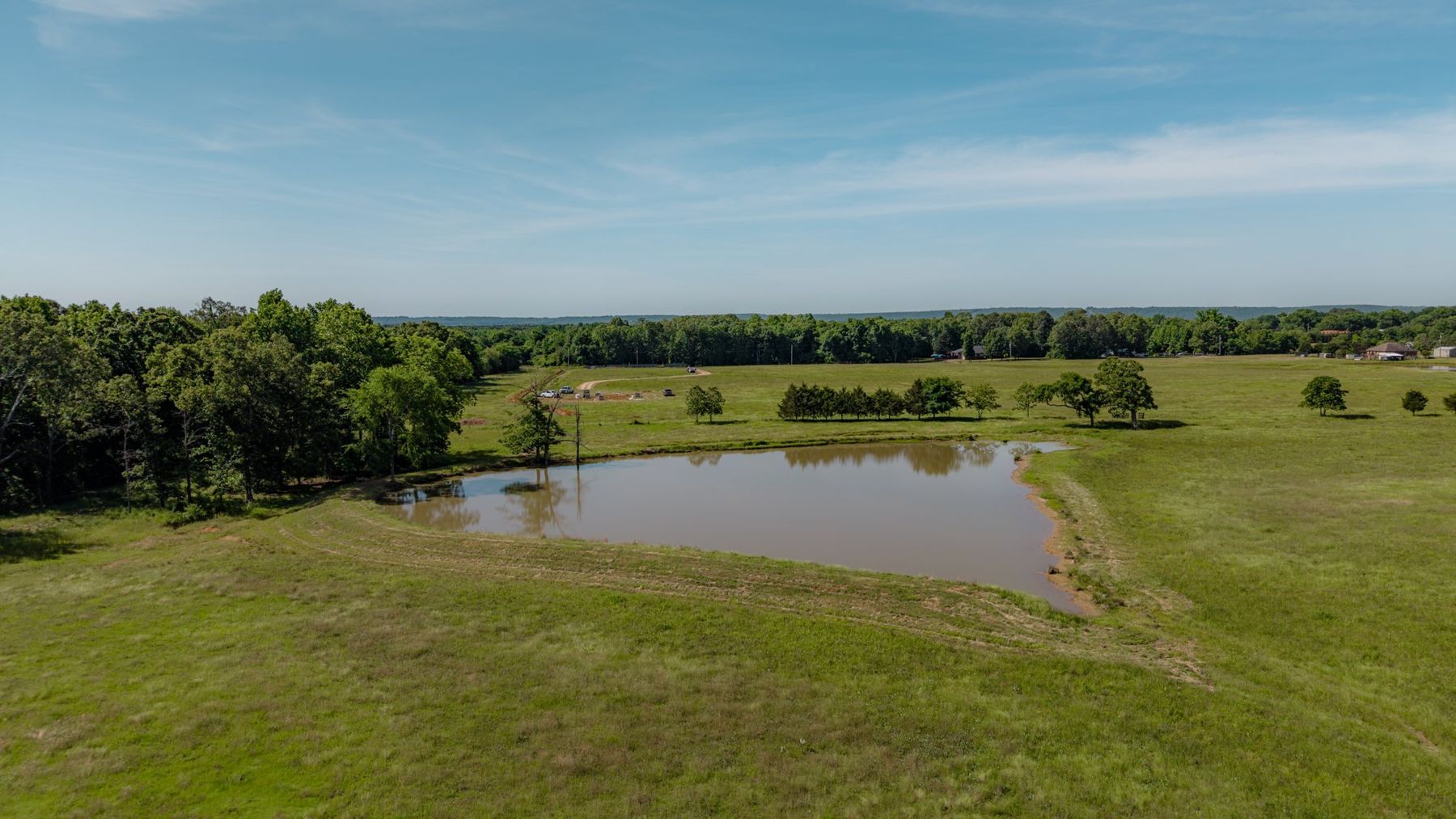 Drone aerial of open farmland and a pond